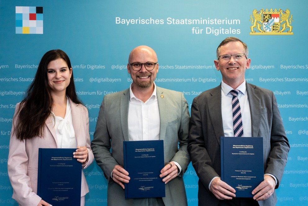 Prof. Dr. Meinhard Schr&ouml;der und Silvie Hilz von der Universit&auml;t Passau bei der &Uuml;bergabe des Gutachtens an Digitalminister Dr. Fabian Mehring (Mitte); Foto: Bayerisches Staatsministerium f&uuml;r Digitales