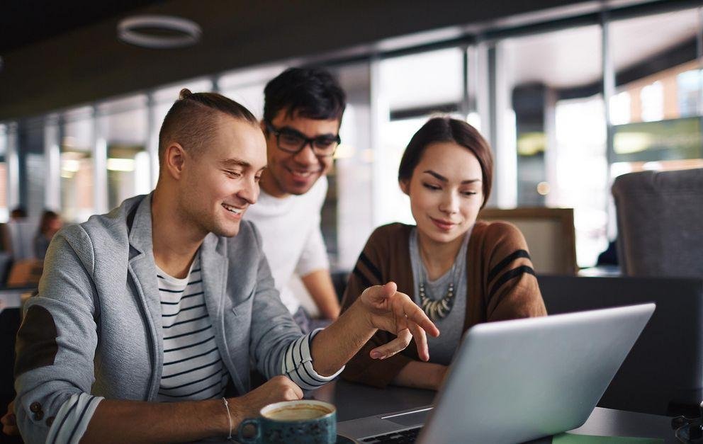 Three young adults in front of laptop Three young adults in front of laptop