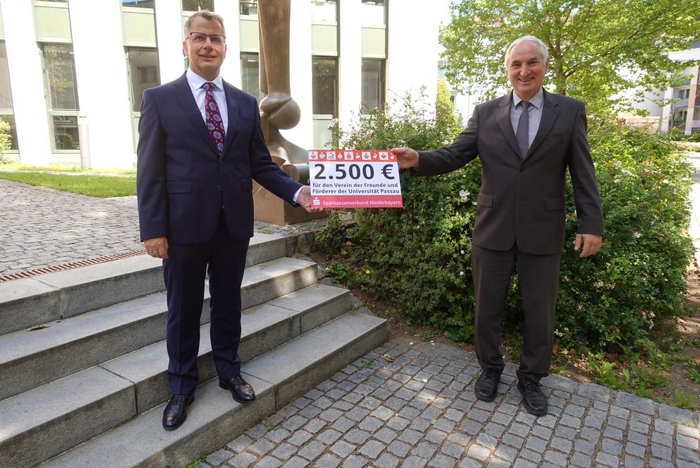 Das Bild zeigt Christoph Helmschrott und Präsident Prof. Dr. Ulrich Bartosch bei der Spendenübergabe. Foto: Universität Passau 
