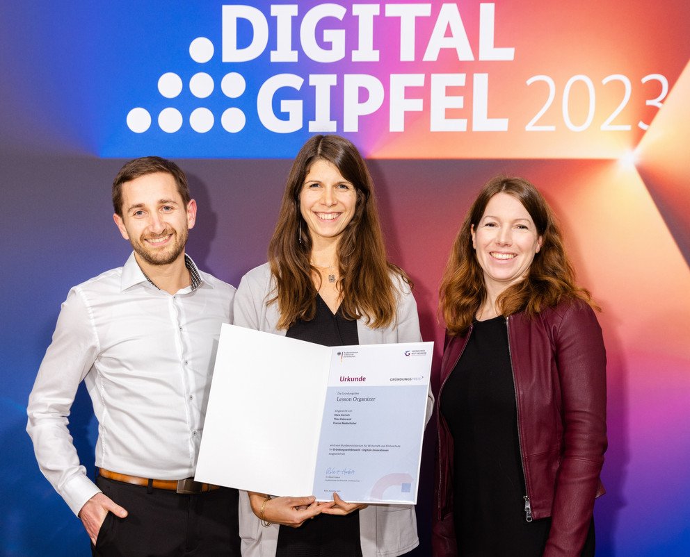 Das Passauer Gründungsteam um Thea Kakavand (Mitte), Florian Niederhuber (li.), Klara Gorisch und Tristan Schneider (beide nicht im Bild) hat mit dem Projekt „Lesson Organizer“ am 20. November in Jena einen Preis beim „Gründungswettbewerb – Digitale Innovationen“ gewonnen. Rechts im Bild: Moderatorin Anna Christmann. Foto: BMWK/Philipp Kirschner.