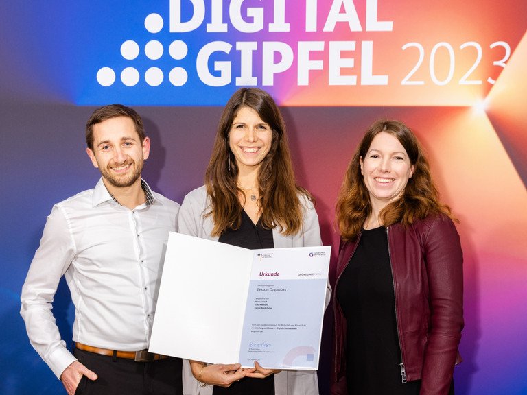 Das Passauer Gründungsteam um Thea Kakavand (Mitte), Florian Niederhuber (li.), Klara Gorisch und Tristan Schneider (beide nicht im Bild) hat mit dem Projekt „Lesson Organizer“ am 20. November in Jena einen Preis beim „Gründungswettbewerb – Digitale Innovationen“ gewonnen. Rechts im Bild: Moderatorin Anna Christmann. Foto: BMWK/Philipp Kirschner.