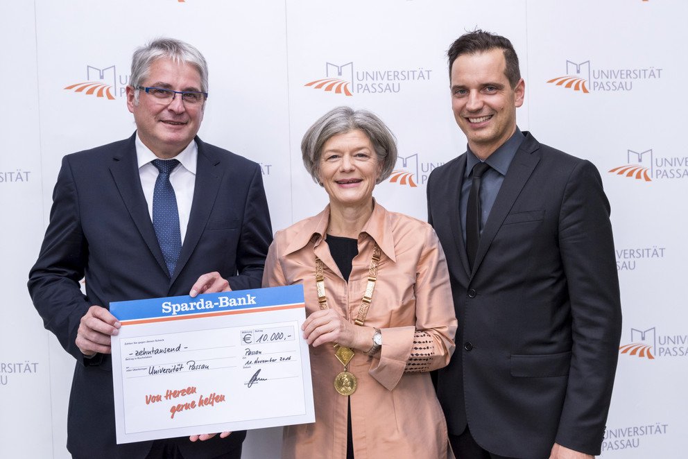 Johannes Lechner, Vorstand des Bankhauses (links), und Andreas Raitner, Leiter der Sparda-Bank-Filiale Passau, &uuml;bergaben im Namen der Stiftung den Spendenscheck an Universit&auml;tspr&auml;sidentin Prof. Dr. Carola Jungwirth. Foto: Universit&auml;t Passau