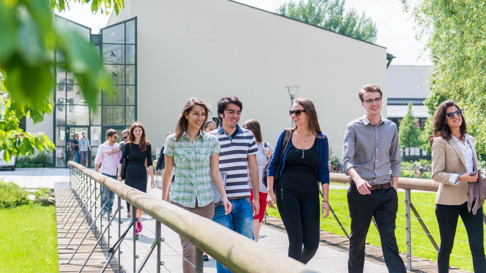 Studierende laufen über die Brücke vor der Fakultät für Informatik und Mathematik