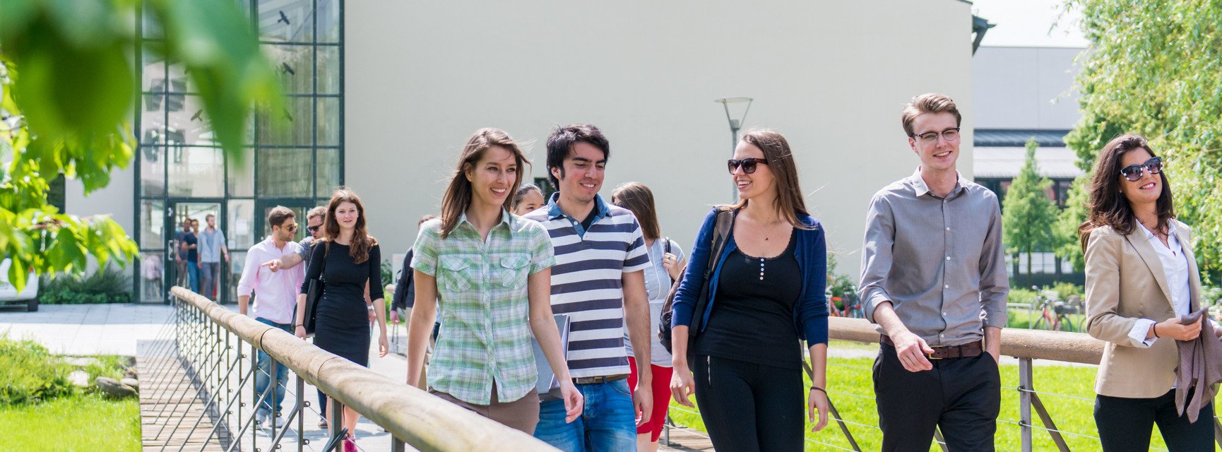 Studierende laufen über die Brücke vor der Fakultät für Informatik und Mathematik