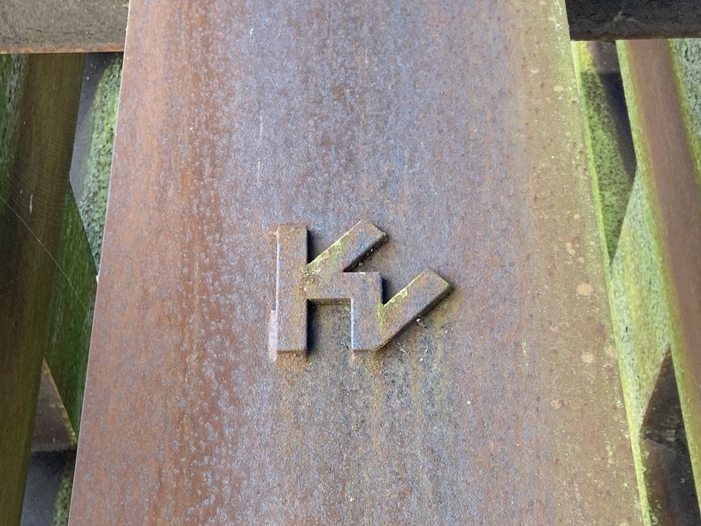 Detailansicht der Skulptur, zu sehen ein plastisches hervorstehendes Emblem