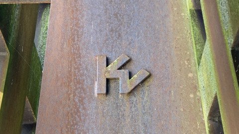 [Translate to Tschechisch:] Detailansicht der Skulptur, zu sehen ein plastisches hervorstehendes Emblem