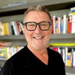 Foto von Christian Bernreiter vor Bücherregal