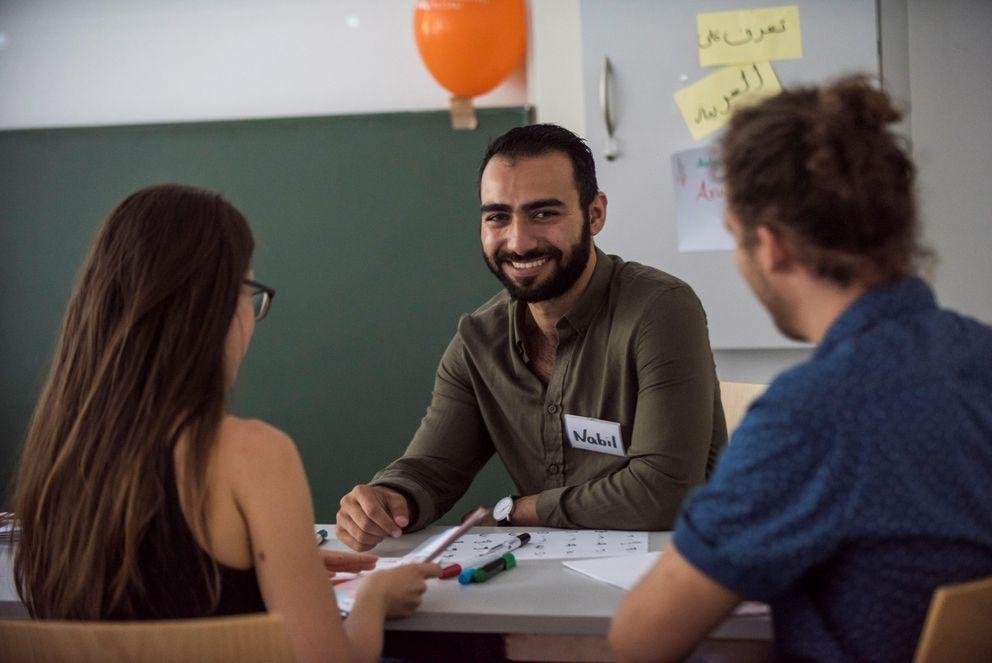 Drei Studierende sitzen um einen Tisch Drei Studierende sitzen um einen Tisch