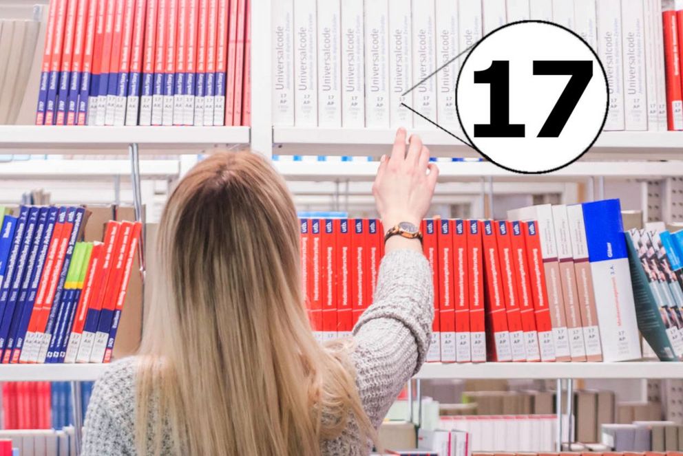 A student in front of a textbook collection, the location code beginning with "17"