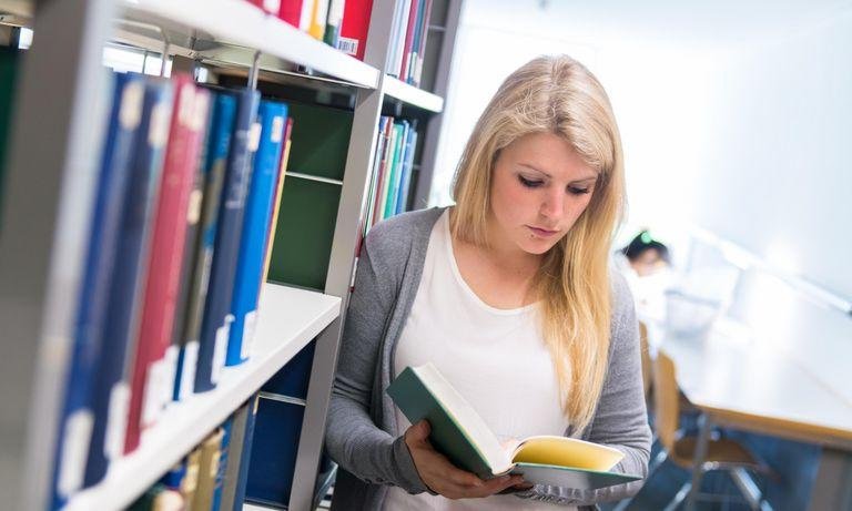 Student in the library with a book