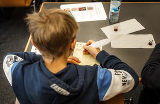 Kind schreibt mit Feder und Tinte