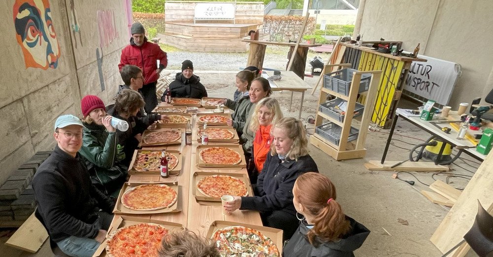 Mitglieder des Kulturtransport essen gemeinsam Pizza