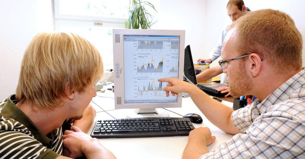 Academics in front of a desktop computer