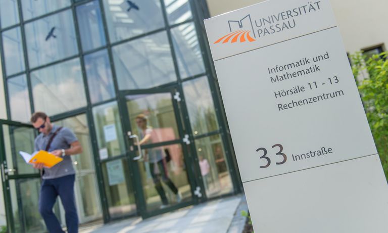 Ein Student kommt aus dem Gebäude der Fakultät für Informatik und Mathematik heraus