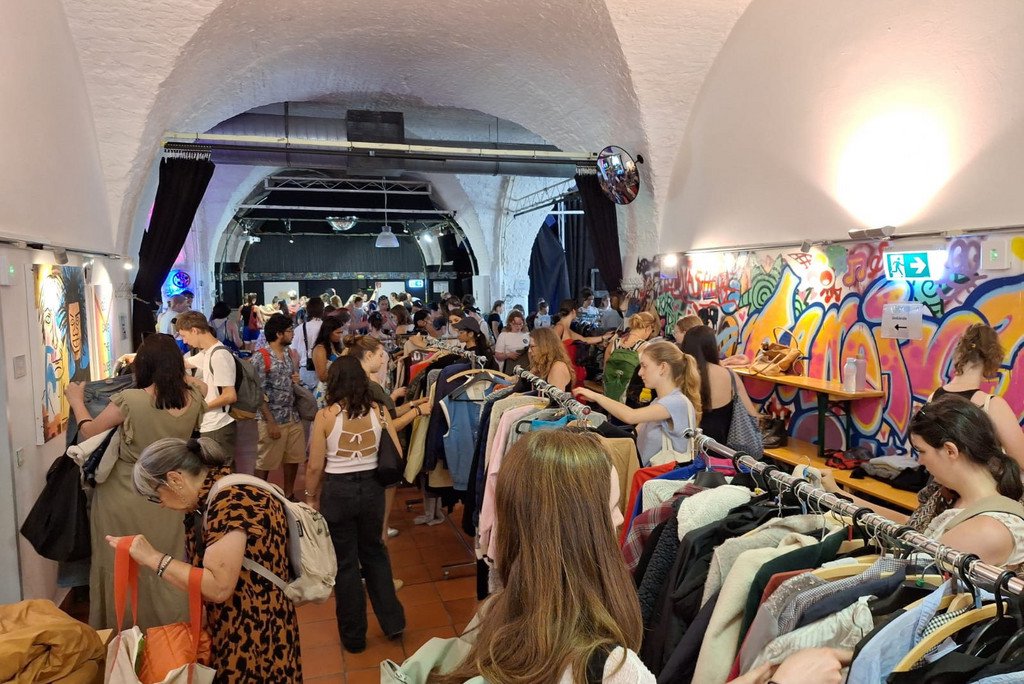 Raum voller Menschen mit vielen Kleiderst&auml;ndern 