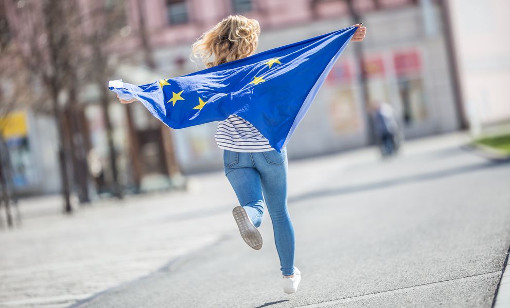 [Translate to Englisch:] Eine laufende Frau mit einer Europaflagge