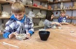 [Translate to Englisch:] Kinder beim Arbeiten mit Ton in der Keramikwerkstatt