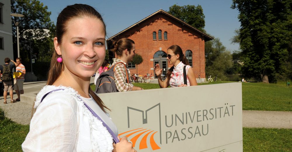 Female student in front of the stele with the university logo