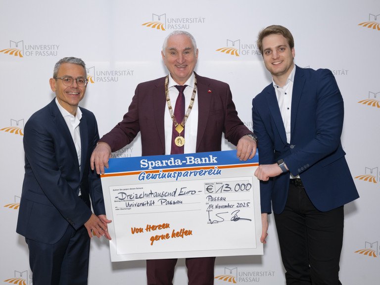 Michael Gruber, Vorstandsvorsitzender der Sparda-Bank Ostbayern eG (li) und Stephan Brandler, Leiter der Sparda-Bank-Filiale Passau (re) bei der Übergabe des Spendenschecks an Universitätspräsident Prof. Dr. Ulrich Bartosch (Mitte); Foto: Universität Passau