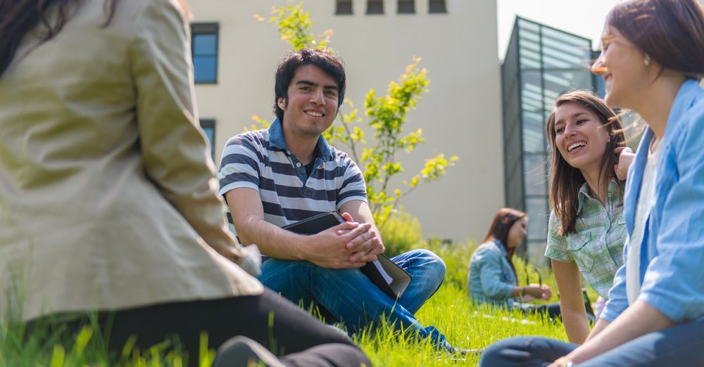 Students sitting on the lawn in front of the FIM building