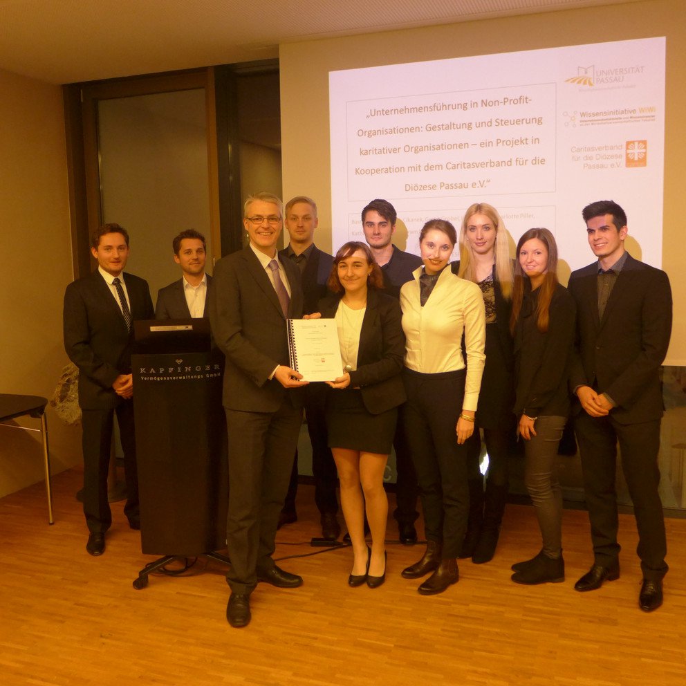 &Uuml;bergabe des Abschlussberichts; von links nach rechts: 1.Reihe: Caritas-Vorstand Dr. Wolfgang Kues, Katharina Reitenauer und Charlotte Piller, 2. Reihe: Robert Richter, Robert Pfeffer, Gerrit Grobel, Bastian Berger, Isabell Ott, Sarah Cikanek und Aram Wejda