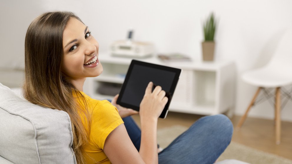Eine Studentin hält ein Tablet in der Hand