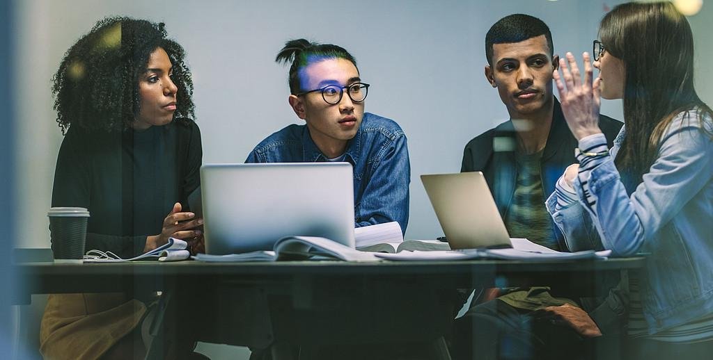 Studierende hören einer anderen Studierenden zu