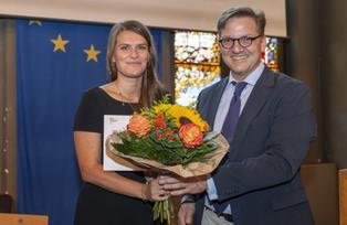 [Translate to Französisch:] Das Bild zeigt die Preisträgerin (Dembruk) und den Laudator (Issler).