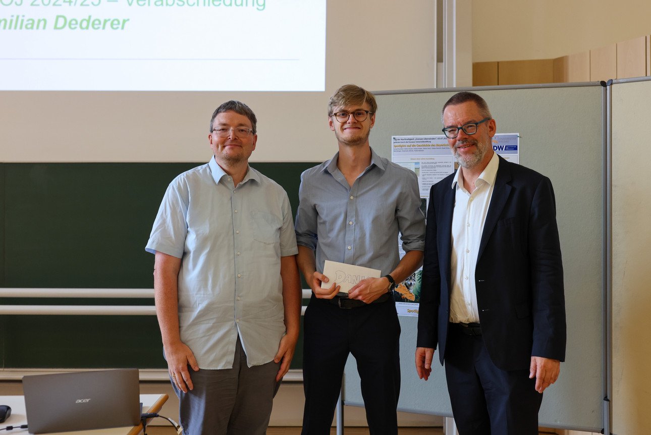 Maximilian Dederer, der sein Freiwilliges &Ouml;kologisches Jahr an der Universit&auml;t Passau absolviert hat, steht mit seinem Pr&auml;sent im Audimax neben Florian Stelzer und Prof. Dr. Werner Gamerith.