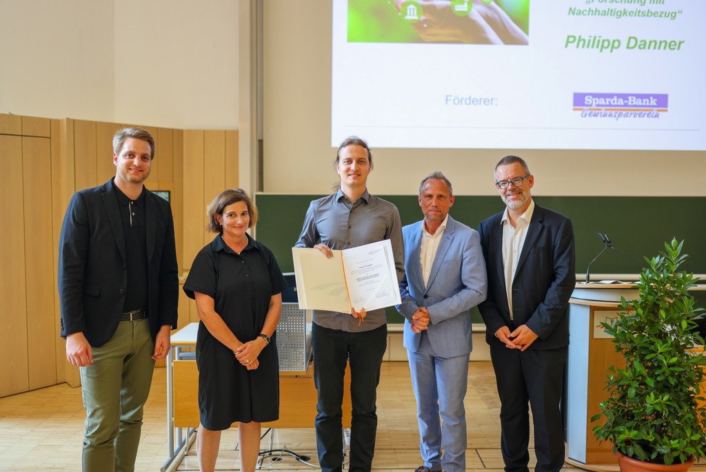Philipp Danner erh&auml;lt am 3.7.2025 den Forschungspreis f&uuml;r Nachhaltigkeit der Universit&auml;t Passau 2025. Danner steht zwischen Stephan Brandler (Leiter der Sparda-Bank-Filiale Passau), Prof. Dr. Bettina Noltenius (Vizepr&auml;sidentin der Universit&auml;t Passau), Staatsminister Thorsten Glauber (Bayerisches Staatsministerium f&uuml;r Umwelt und Verbraucherschutz), Prof. Dr. Werner Gamerith (Vizepr&auml;sident der Universit&auml;t Passau).