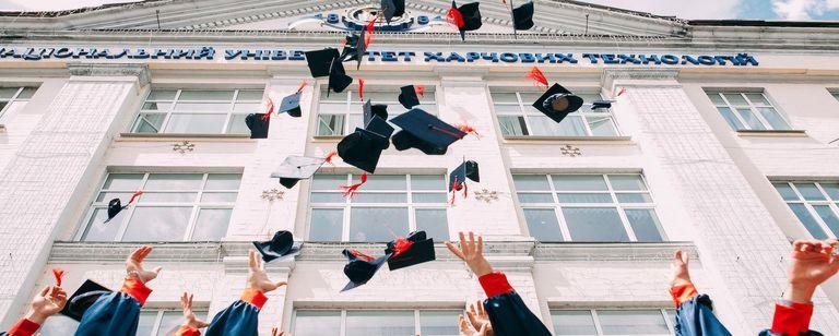 Dekoration: Hände werfen Doktorhüte in die Luft