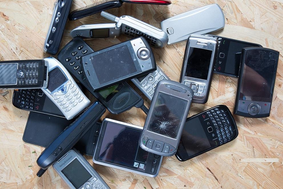 Old and obsolete cellphone on wooden background