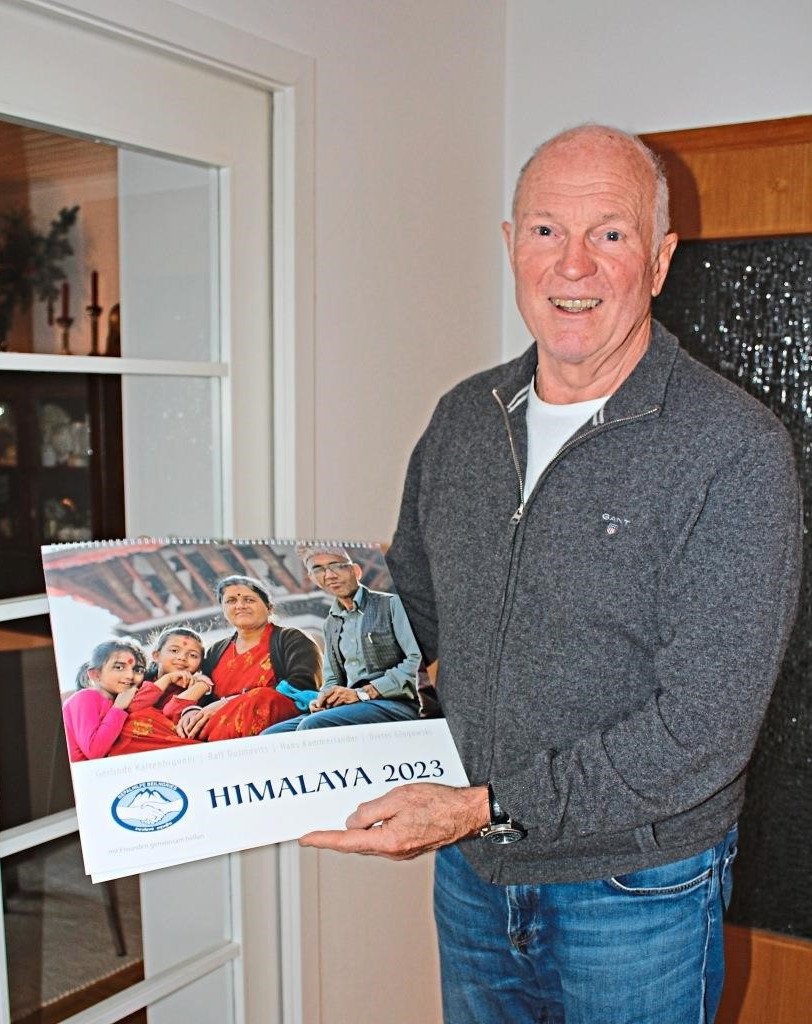 Michael Rebele hälz Himalayakalender hoch.