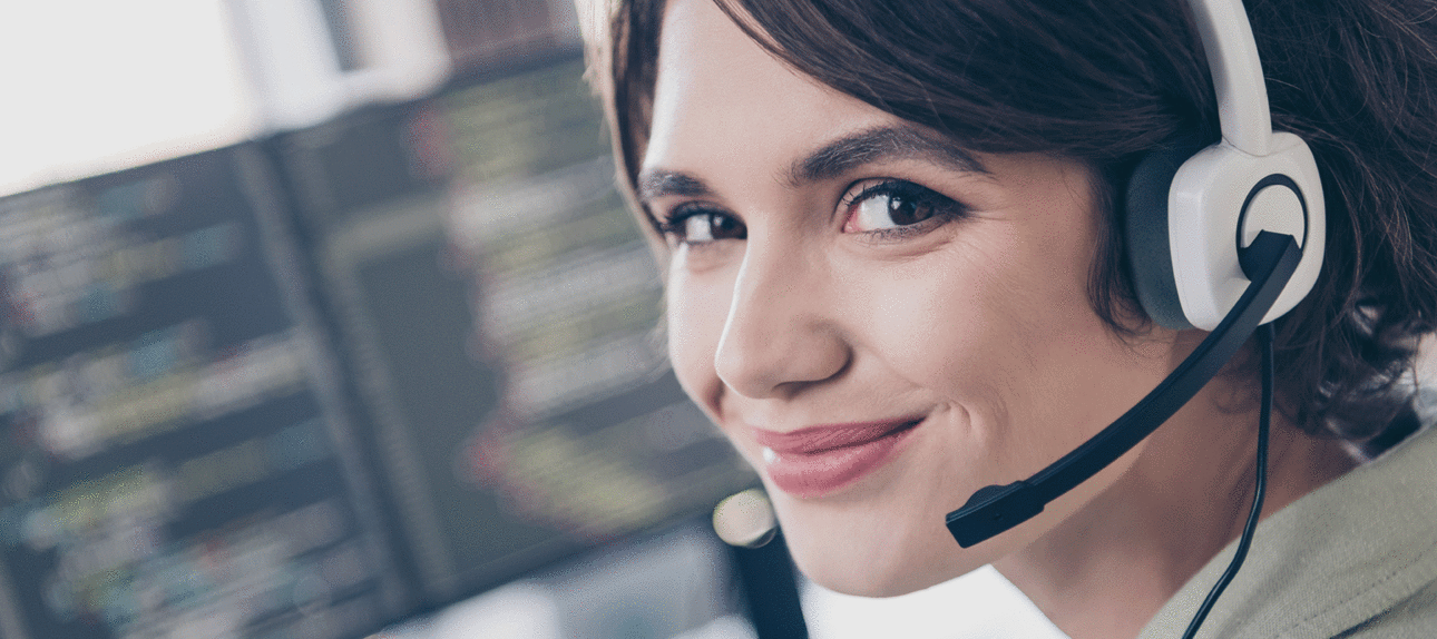 Frau l&auml;chelt mit Headset in die Kamera