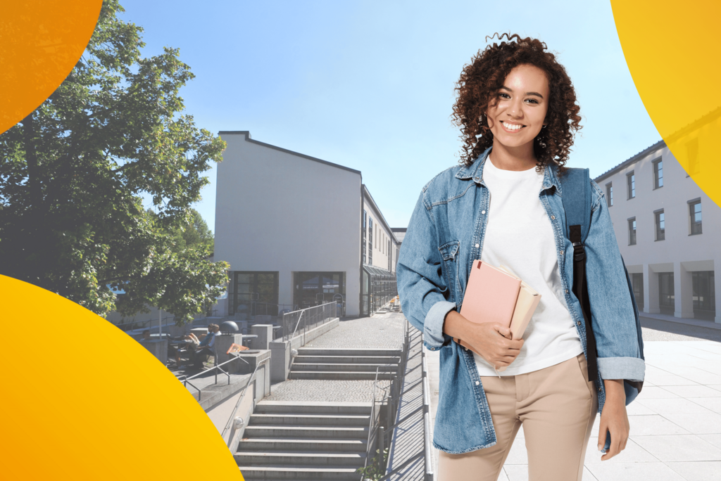 Auf dem Bild sieht man eine Frau, die sich auf dem Mensavorplatz der Universität Passsau befindet und in die Kamera lächelt.