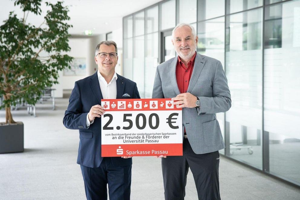 Präsident Prof. Dr. Ulrich Bartosch (r.) freut sich über den Scheck in Höhe von 2.500 Euro der niederbayerischen Sparkassen, übergeben von Christoph Helmschrott, Vorstandsvorsitzender der Sparkasse Passau. Foto: Universität Passau