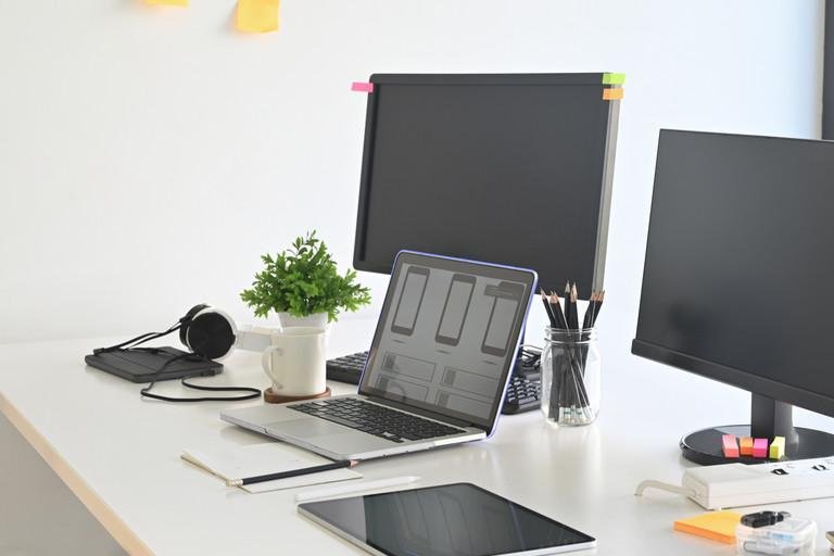 Workspace programmer with laptop and computer pc on table.