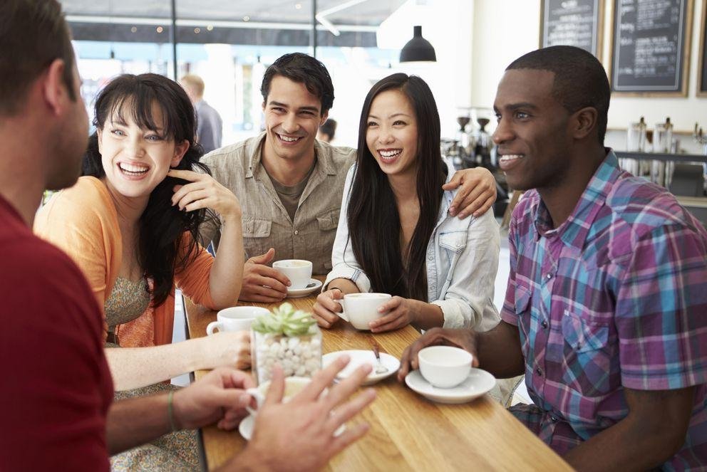 Five people sitting at a table talking