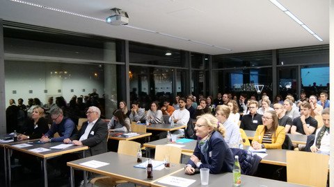 Das Publikum hört gespannt zu beim Abschlussevent des Fünf Euro Business Wettbewerbs 2024. 