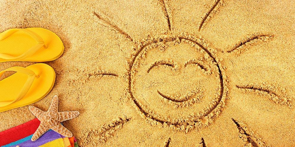 Lachende Sonne gemalt im Sand