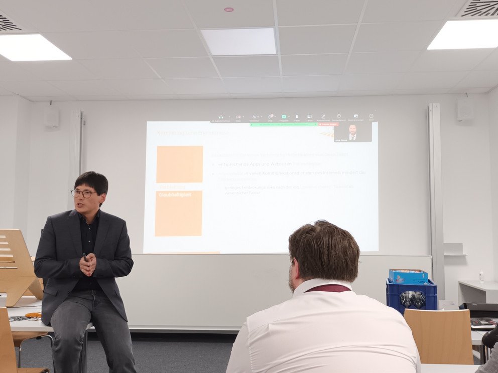 Prof. Dr. Valerius sitzt vor den Teilnehmenden