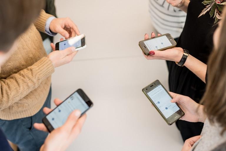 Studierende rufen auf dem Smartphone die Webanwendung classEx auf, mit deren Hilfe sie im Hörsaal an interaktiven Experimenten und Umfragen teilnehmen können.