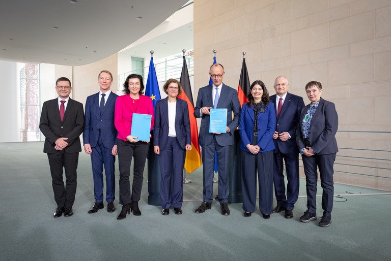&Uuml;bergabe des Jahresgutachtens 2026 der EFI-Kommission an Bundeskanzler Friedrich M&auml;rz; v.l. Guido B&uuml;nstorf, Joachim Henkel, Dorothee B&auml;r, Irene Bertschek, Friedrich Merz, Carolin H&auml;ussler, Christoph M. Schmidt, Friederike Welter; Foto: Linda K&ouml;hler-Sandring.