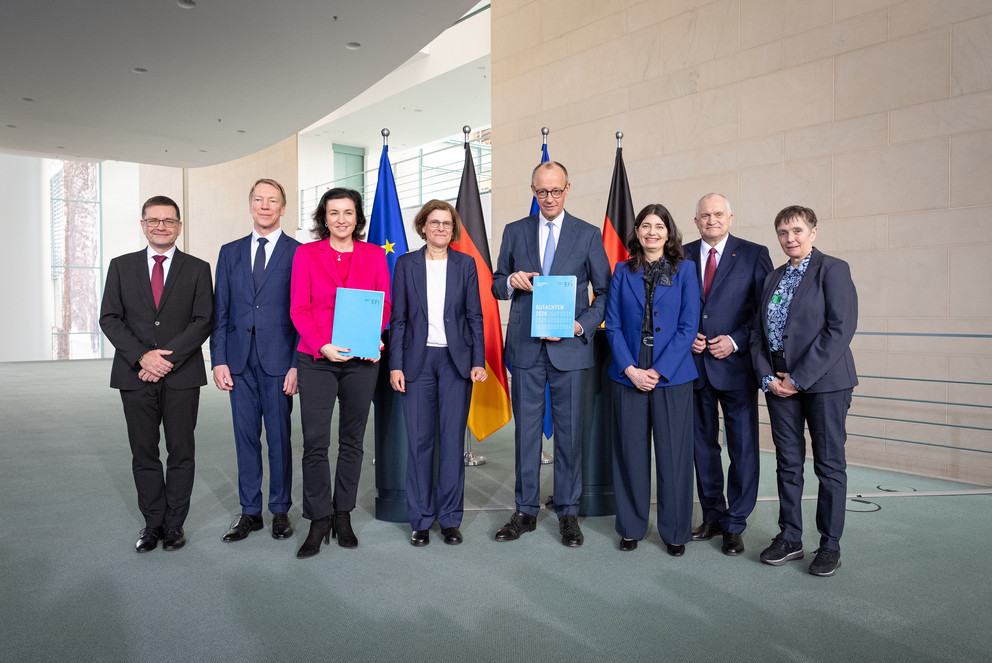 &Uuml;bergabe des Jahresgutachtens 2026 der EFI-Kommission an Bundeskanzler Friedrich M&auml;rz; v.l. Guido B&uuml;nstorf, Joachim Henkel, Dorothee B&auml;r, Irene Bertschek, Friedrich Merz, Carolin H&auml;ussler, Christoph M. Schmidt, Friederike Welter; Foto: Linda K&ouml;hler-Sandring.