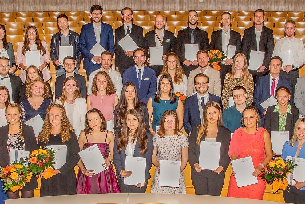 Die Absolventinnen und Absolventen der Dekan der Wirtschaftswissenschaftlichen Fakultät mit Dekan Prof. Dr. Stefan Bauernschuster (li.), und Studiendekan, Prof. Dr. Sebastian Krautheim (re.) Foto: Atelier Kaps 