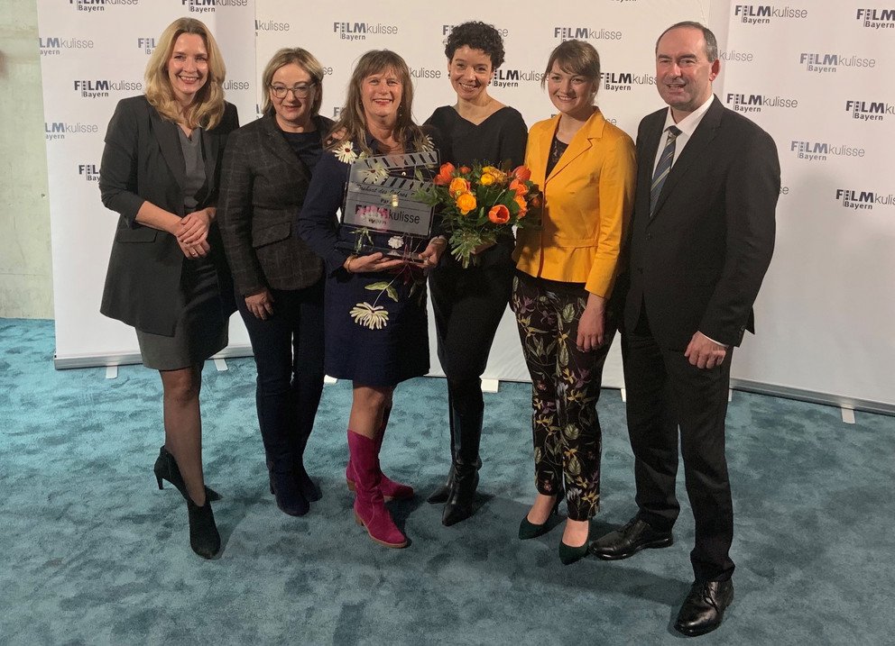 Pia Olligschläger and Katrina Jordan accept the glass clapperboard from Ministers Judith Gerlach and Hubert Aiwanger. Image credit: University of Passau
