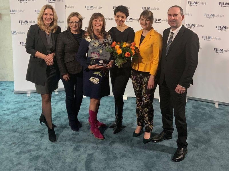 Pia Olligschläger and Katrina Jordan accept the glass clapperboard from Ministers Judith Gerlach and Hubert Aiwanger. Image credit: University of Passau