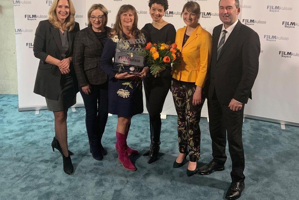 Pia Olligschläger and Katrina Jordan accept the glass clapperboard from Ministers Judith Gerlach and Hubert Aiwanger. Image credit: University of Passau