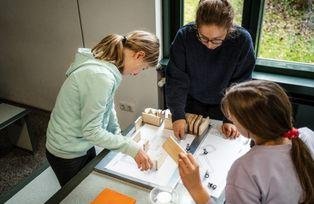 Kinder im Workshop "Mathematik zum Anfassen" lösen ein geometrisches Rätsel