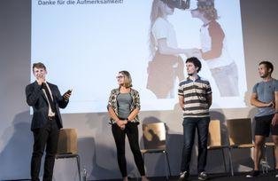 Moderator Michael Luppert der Hochschulgruppe Science Slam gibt die Siegerin und den Sieger bekannt